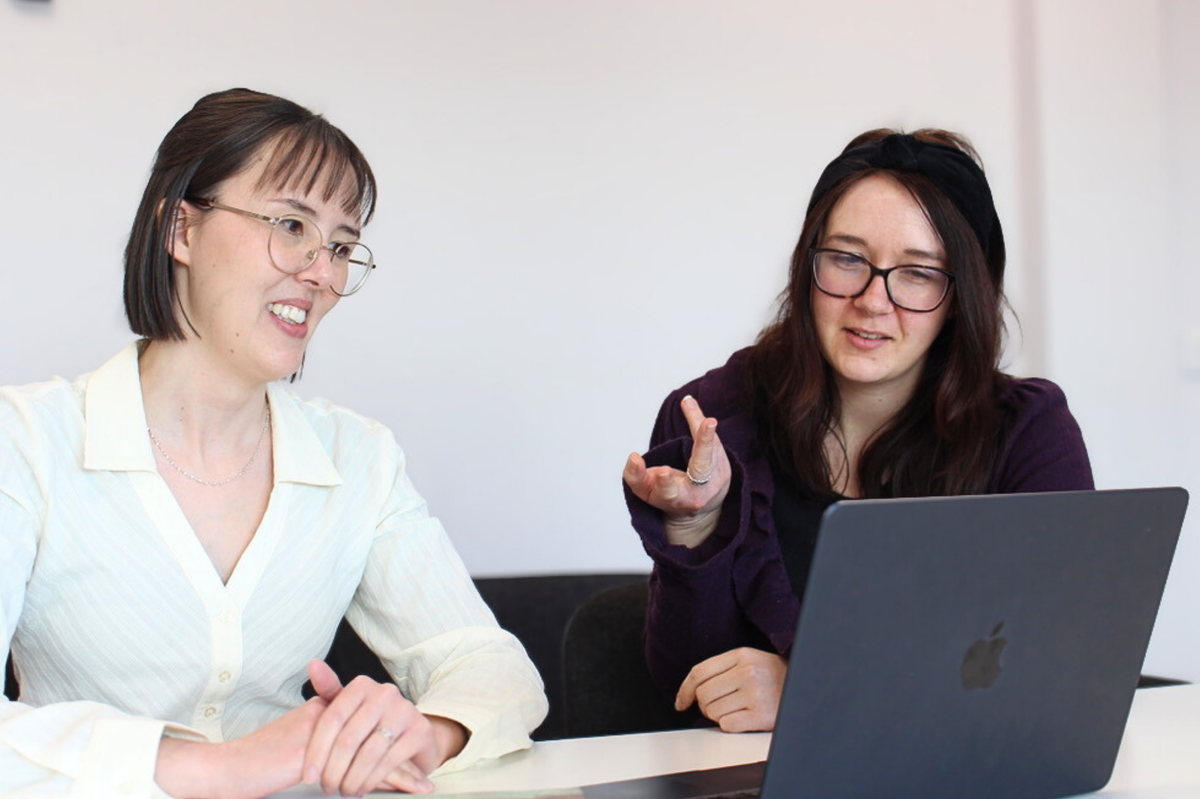 Two women looking at a laptop in a meeting