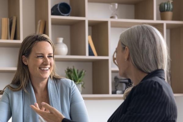 Two women smiling and talking