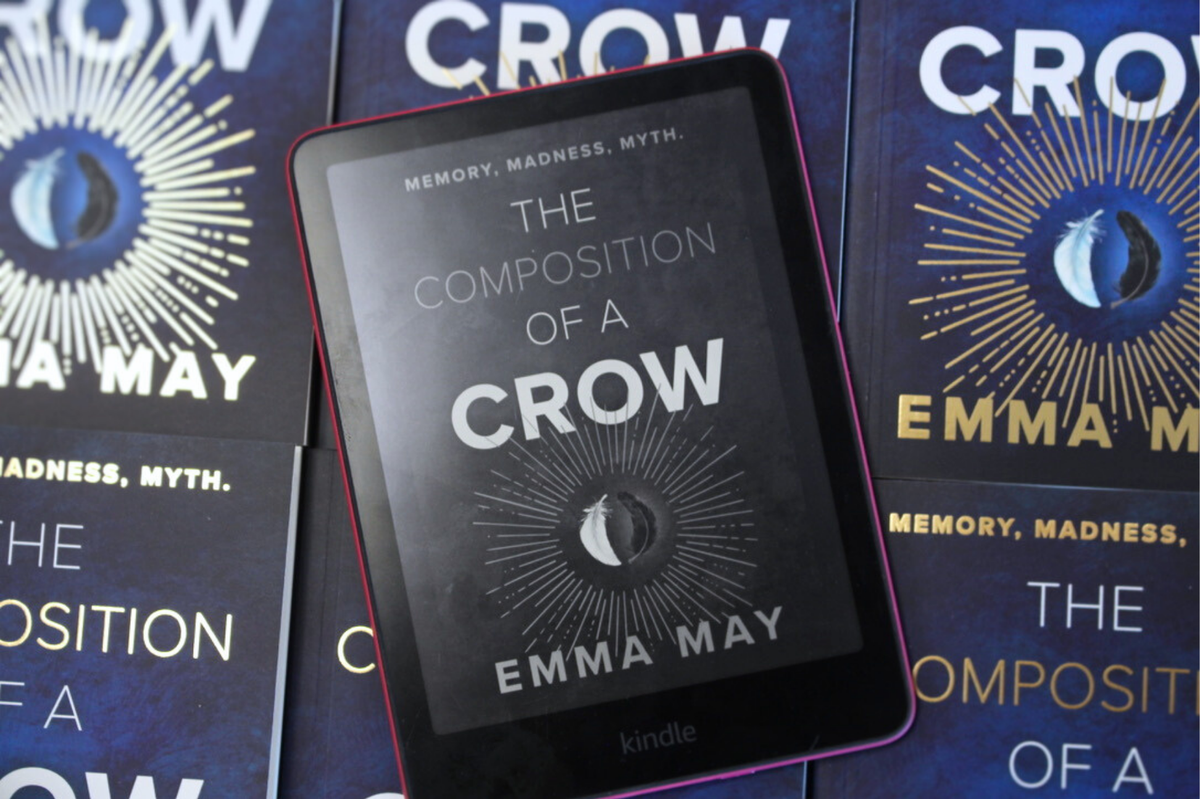 A kindle with 'Composition of a Crow', by the Book Guid, in front of other copies