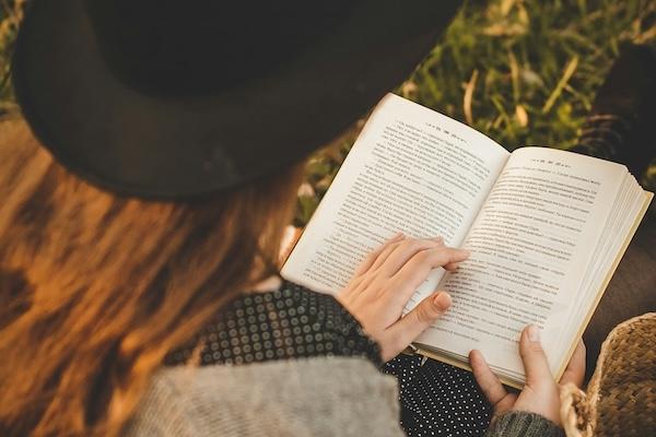 A woman reading a book on the grass