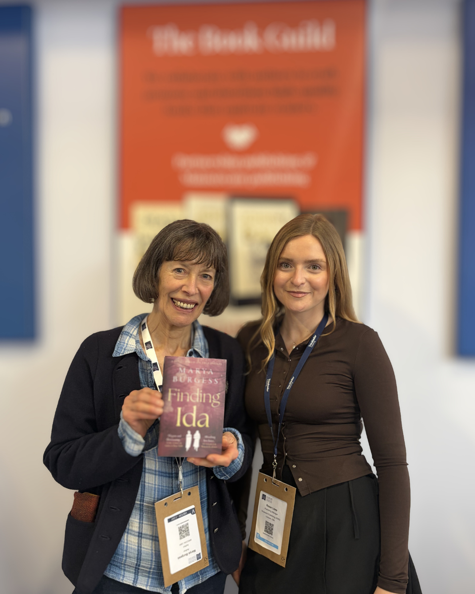 Man smiling and reading a book in the park